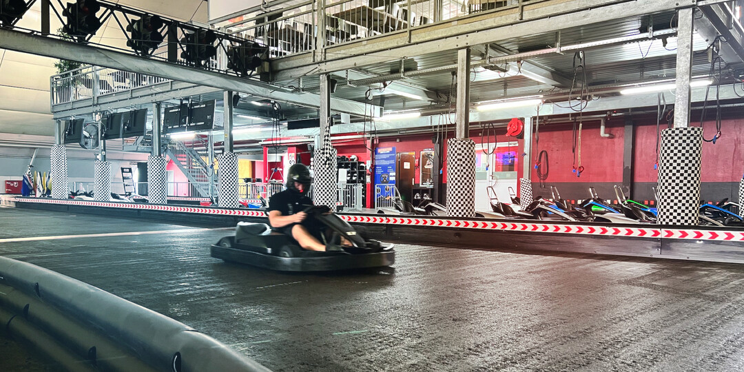 Go-Kart-Bahn mit einem jungen Mann im Go-Kart, der Runden rast.