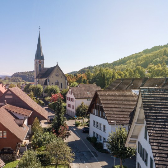 Luftaufnahme von Spreitenbach Dorf mit älteren Gebäuden und der Kirche.
