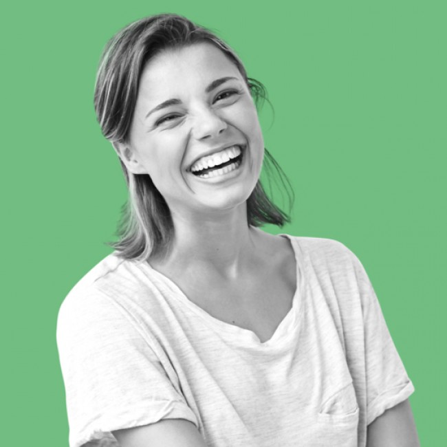 Schwarz-Weiss- Bild einer jungen Frau die lacht, auf grünem Hintergrund.